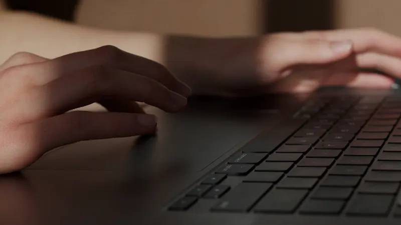Person working on a laptop in an office, drafting content with generative AI